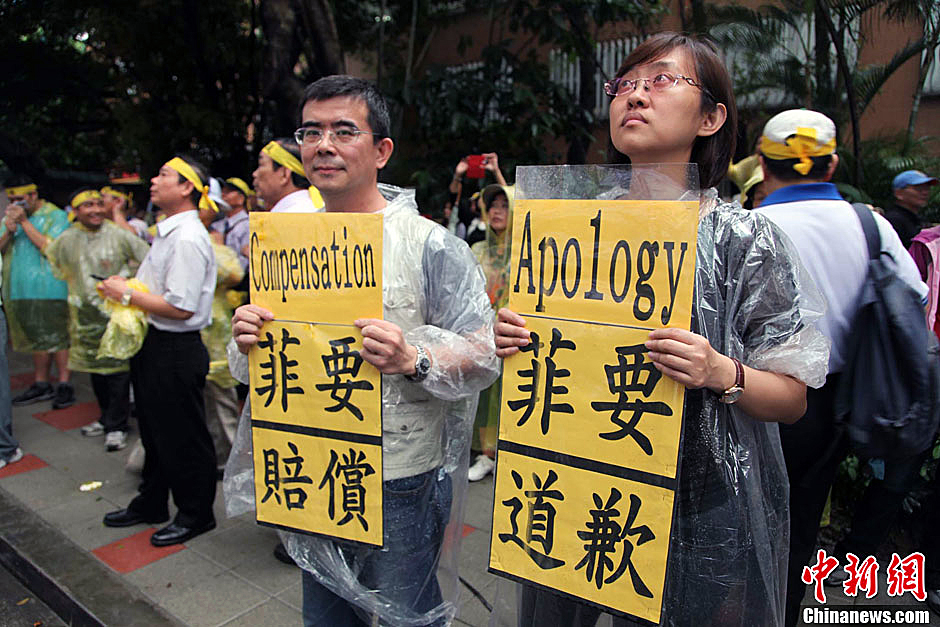 　圖為當天下午，當臺灣數百漁民在馬尼拉經濟文化辦事處前抗議時，有兩名年輕人手持標語，在路邊聲援。中新