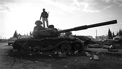 9月8日，敘利亞Zabadani，一名敘利亞反對派武裝人員站在廢棄的政府軍坦克上。