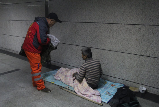 在鄭州一處地下通道，孫德坤挑了幾件衣服送給了流浪者