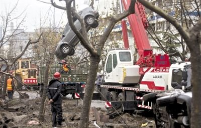 輸油管道爆炸后，搶修人員將被炸毀的車輛運(yùn)出現(xiàn)場(chǎng)。