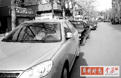 友愛路，路邊停了一排車，本來(lái)不寬的路就變得更窄了。