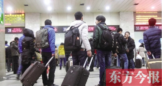 鄭州火車站東廣場售票大廳，幾名學(xué)生在售票窗口前躊躇