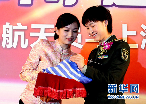 11月1日，航天員劉洋（右）在為“愛心”毛衣編織最后的收尾針。