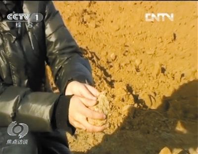 麻剛沙系麻剛石粉碎而成。記者找到一塊麻剛石，一捏就碎成粉末，硬度非常差。央視截圖