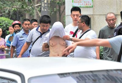昨日，成都警方抓捕時與毒犯發(fā)生槍戰(zhàn)。一名男犯罪嫌疑人被警方押出。