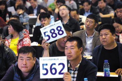 昨日，拍賣現(xiàn)場(chǎng)競拍者舉牌競拍。新京報(bào)記者