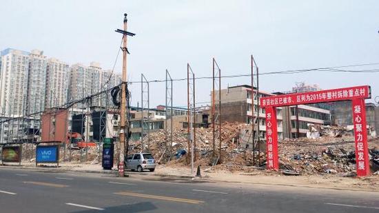 015年5月31日，在社區(qū)干部的帶頭拆遷下，親賢社區(qū)的“城中村改造”拉開(kāi)帷幕。由于前期“清產(chǎn)核資”及補(bǔ)償標(biāo)準(zhǔn)等因素，拆遷改造工作推進(jìn)并不順利。圖為位于體育西路東側(cè)集體所有的商鋪率先被拆遷完畢，用于遮擋的圍擋正在施工中。（拍攝：2015年9月16日）