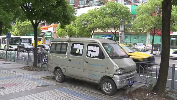 被棄置在人行道上的面包車(chē)。