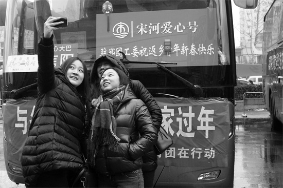 昨天上午8時，鄭州正道中環(huán)百貨廣場，準(zhǔn)備回家的老鄉(xiāng)在愛心大巴車前合影留念