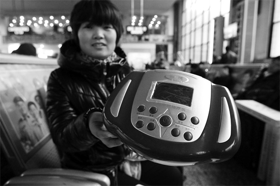 火車站候車室，李女士向記者展示她準備孝敬父母的按摩儀