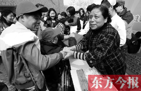 昨日，鄭大四附院的大樓前，“面人鄭”鄭玉芬（右）向前來(lái)捐款的殘疾人表示感謝