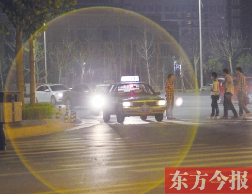 昨晚，鄭州火車東站，一些出租車停靠在路邊，見到行人不時主動搭訕 東方今報暗訪組 攝