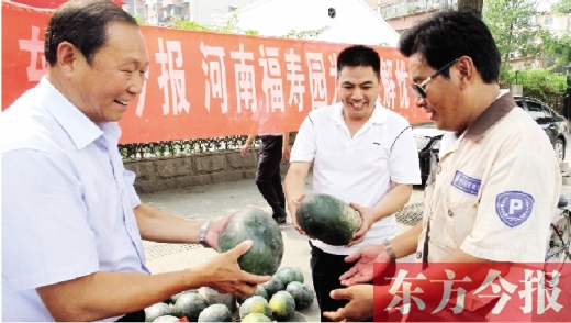 河南福壽園區(qū)域總經(jīng)理吳正宗（左一）、東方今報(bào)發(fā)行中心副總監(jiān)王路喜（中）在街頭給市民送瓜