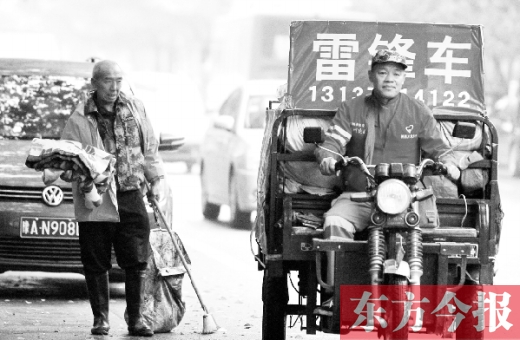 鄭州市商城路，一名環(huán)衛(wèi)工懷抱著剛剛收到的毯子，目送“雷鋒哥”孫德坤離開(kāi)
