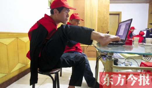 12月2日，一名“豫殘聯(lián)盟”志愿者正通過網(wǎng)絡(luò)、微博等聯(lián)絡(luò)著各地殘疾人朋友 東方今報首席記者 張曉冬