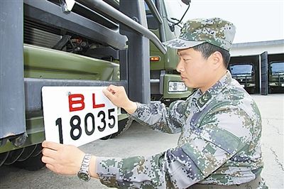駐京某部上士高振超正在認(rèn)真更換新式軍車(chē)號(hào)牌。　　　本報(bào)記者　尹　航攝