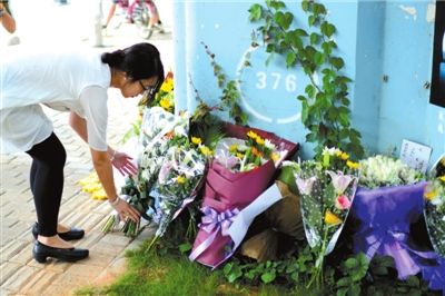 6月8日下午，記者來到廈門公交車爆炸事發(fā)現(xiàn)場橋下，附近已聚集了十幾個自發(fā)前來悼念的市民。橋墩下排放了一圈或黃或白的菊花，還有玖瑰、百合等。