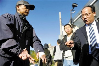 常林鋒在法院外展示雙手，他稱被燙傷的手因刑訊逼供且未得到及時救治