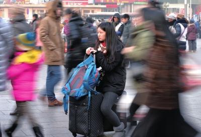 春運(yùn)首日，北京站客流量明顯增多，一名女孩在人流中等待進(jìn)站。