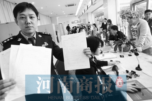 　民警左手拿的是新申請表，右手拿的是三份老申請表 王春勝/攝