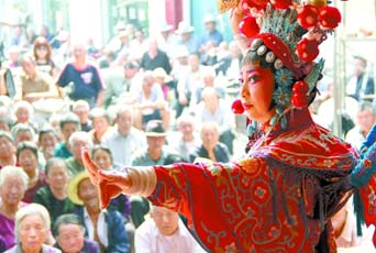 圖為8月15日戲曲演員在“流動舞臺車”上表演傳統(tǒng)地方戲《穆桂英下山》。