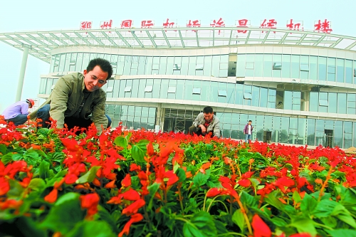9月23日，工人們正在鄭州國際機場許昌候機樓前擺放鮮花。