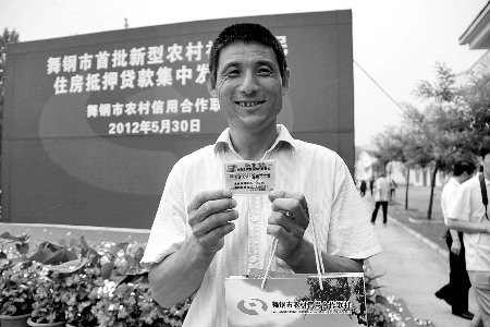 領(lǐng)到貸款，農(nóng)民開心地笑了。