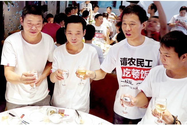 活動發(fā)起人張楠（右二）給農(nóng)民工敬酒。
