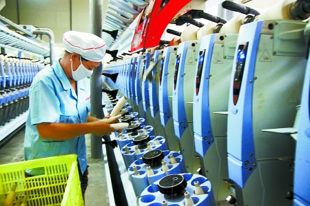 7月3日，在鄧州市永泰棉紡有限公司電腦控制全自動紡紗車間，紡織工人正在生產(chǎn)棉紗。