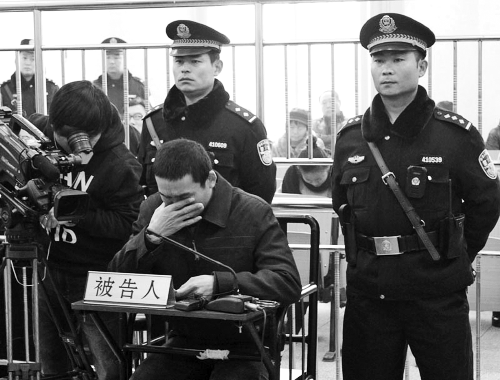 庭審中,29歲的李軍低著頭。