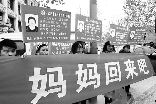 張慧媛老人的子女們舉著尋找母親的牌子和橫幅，在冷風中呼喊著“媽媽，您快回來吧”。