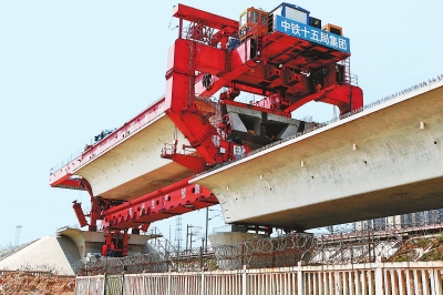 建設(shè)者們操縱巨型起重機(jī)在吊放橋墩。記者鄧放攝
