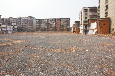 為降塵，旮旯王村拆遷后裸露的地面上鋪了一層石子。