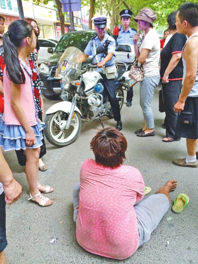 在鄭州優(yōu)勝南路東三街交叉口向東100米處，一名短發(fā)中年女子平躺在路南快車(chē)道上，身旁還有一只掉落的拖鞋