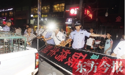 7月8日晚，鄭州市商城路一家占道經營的攤販招牌被執(zhí)法隊員“登記保存”