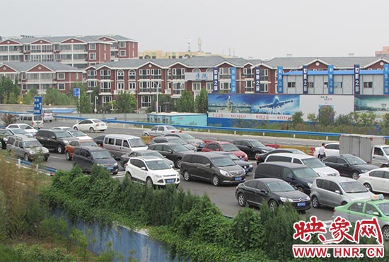 記者看到鄭州機場收費站口車輛排隊，與此形成鮮明對比的是，路的對面（另一半幅）卻車輛較少，通行順暢。