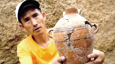 　　考古工作人員展示出土的仰韶文化時(shí)期代表性彩陶。