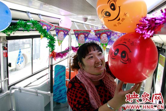 鄭州快速公交B3區(qū)間線車長(zhǎng)李鵬云在車廂里懸掛氣球，布置圣誕車廂，營(yíng)造歡樂圣誕氛圍