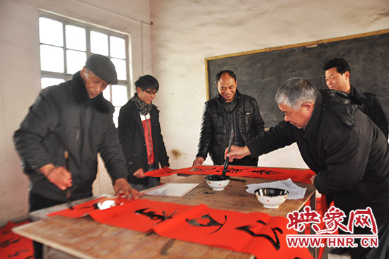鞏義市魯莊鎮(zhèn)農(nóng)民書法愛好者正在寫春聯(lián)。