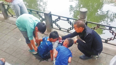 男孩被救出后，圍觀群眾幫他控水換衣服。