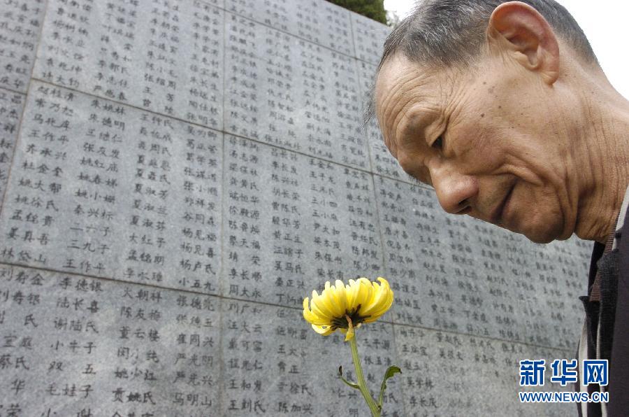 2006年4月5日，74歲的南京大屠殺幸存者佘子清手捧鮮花，祭奠被日軍殺害的母親。