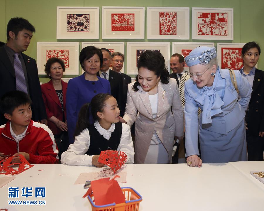 這是彭麗媛和瑪格麗特二世與根據(jù)安徒生童話中人物和情節(jié)制作剪紙的孩子交談。