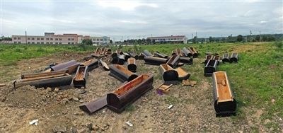 40多副棺木被砸壞后，扔在荒地上。