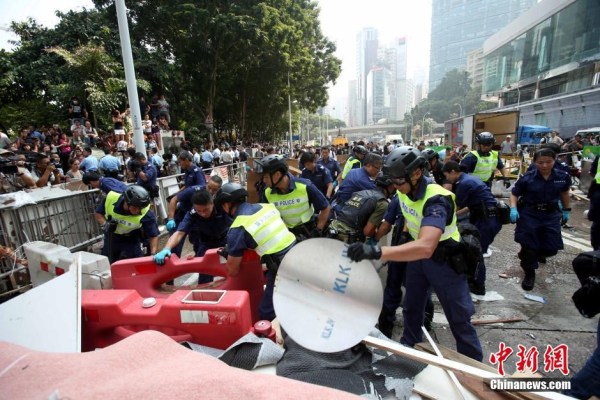 10月14日，警方清除金鐘道障礙物。大批警員在金鐘道現(xiàn)場清拆障礙物。部分警員戴上頭盔將障礙物移走。