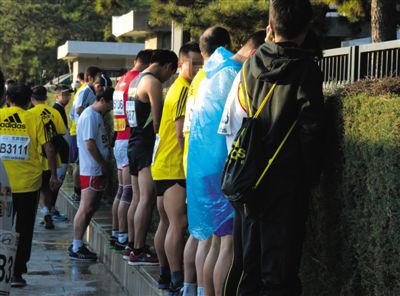 2013年10月20日，北京馬拉松比賽，由于廁位有限，一些選手在綠化帶“就地解決”。圖/IC
