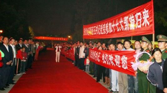 “夾道歡迎”中不少人打出橫幅，路上被鋪上了紅毯。