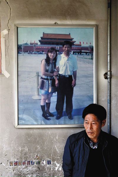 11月14日，承德市平泉縣，潘小梅父母的家，潘小梅父親靠在墻上，身后掛著數(shù)年前他和潘小梅在北京的合影照片。新京報記者
