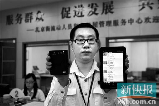 　越秀區(qū)北京街出租屋外來暫住人員管理服務(wù)中心的工作人員展示到出租屋登記來穗人員信息的儀器。
