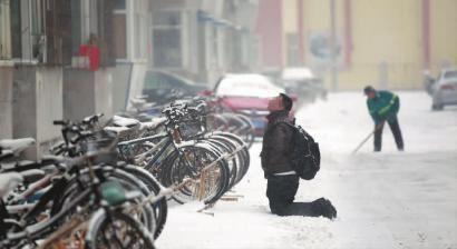 小伙子跪在樓前，一直抬頭看著樓上。 孫立國(guó)/攝