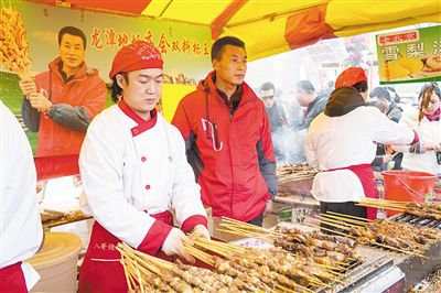 賣羊肉串攤位老板趙山（穿紅衣者）。新京報記者
